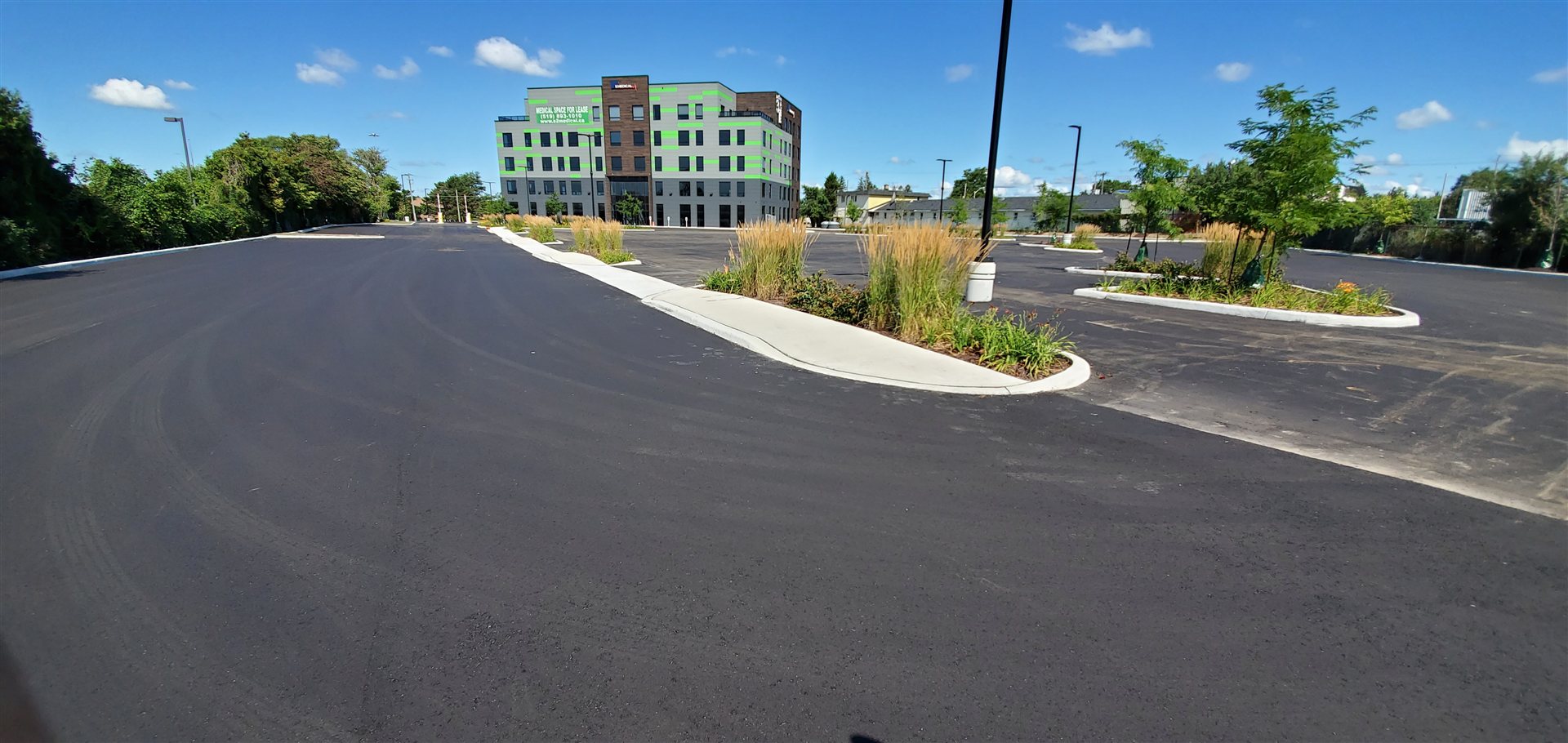 An O'Brien Paving commercial asphalt project with concrete curbs and landscaped islands